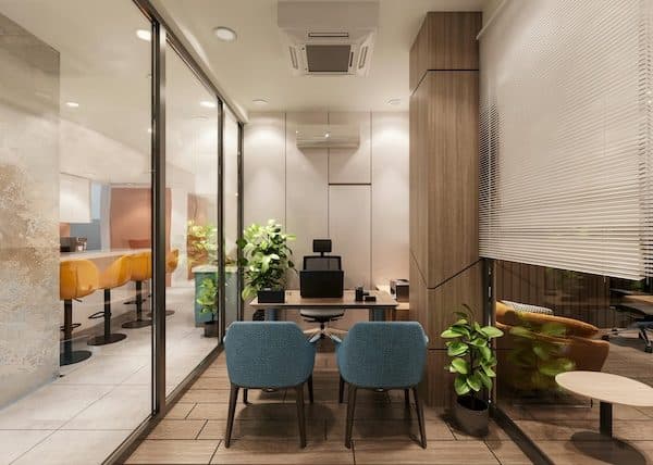 Glass-walled private office with a desk and two teal guest chairs, timber panelling, and a cafe counter beyond the glass