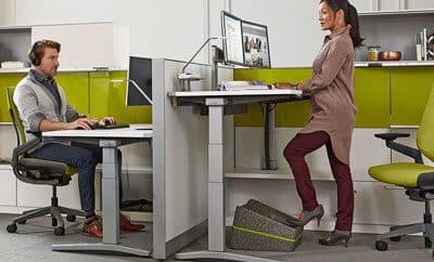 2 people working in an office by OFDC Commercial Interiors. Woman is at standing desk