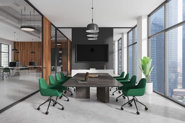 Conference room with a stone-topped table, green swivel chairs, wall display and floor-to-ceiling city windows