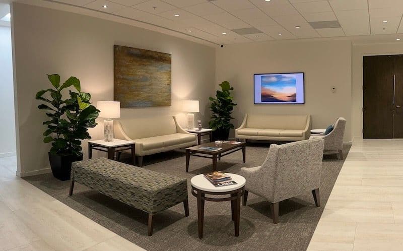 Finished law-office lobby at Icard Merrill in Sarasota, with lounge seating, side tables, and planting installed by OFDC