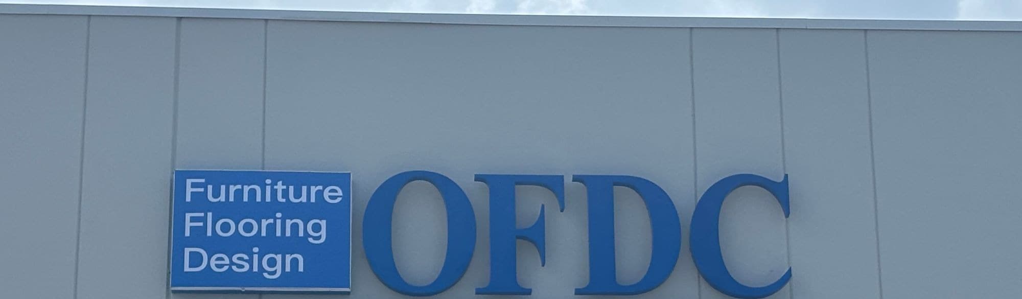 OFDC Sarasota exterior sign: blue dimensional OFDC lettering beside a panel reading Furniture, Flooring, Design