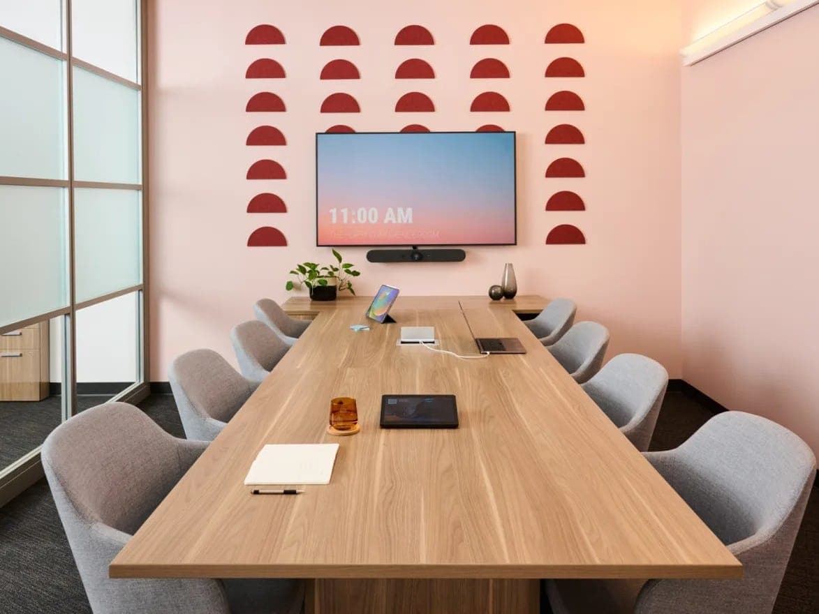 Conference room with a long AMQ Embank wood table and gray chairs