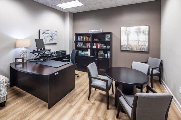 A nice office space with light wood flooring and office furniture.