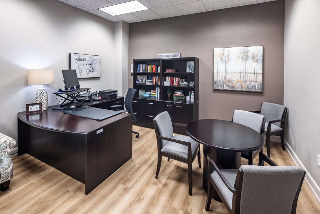 A nice office space with light wood flooring and office furniture.